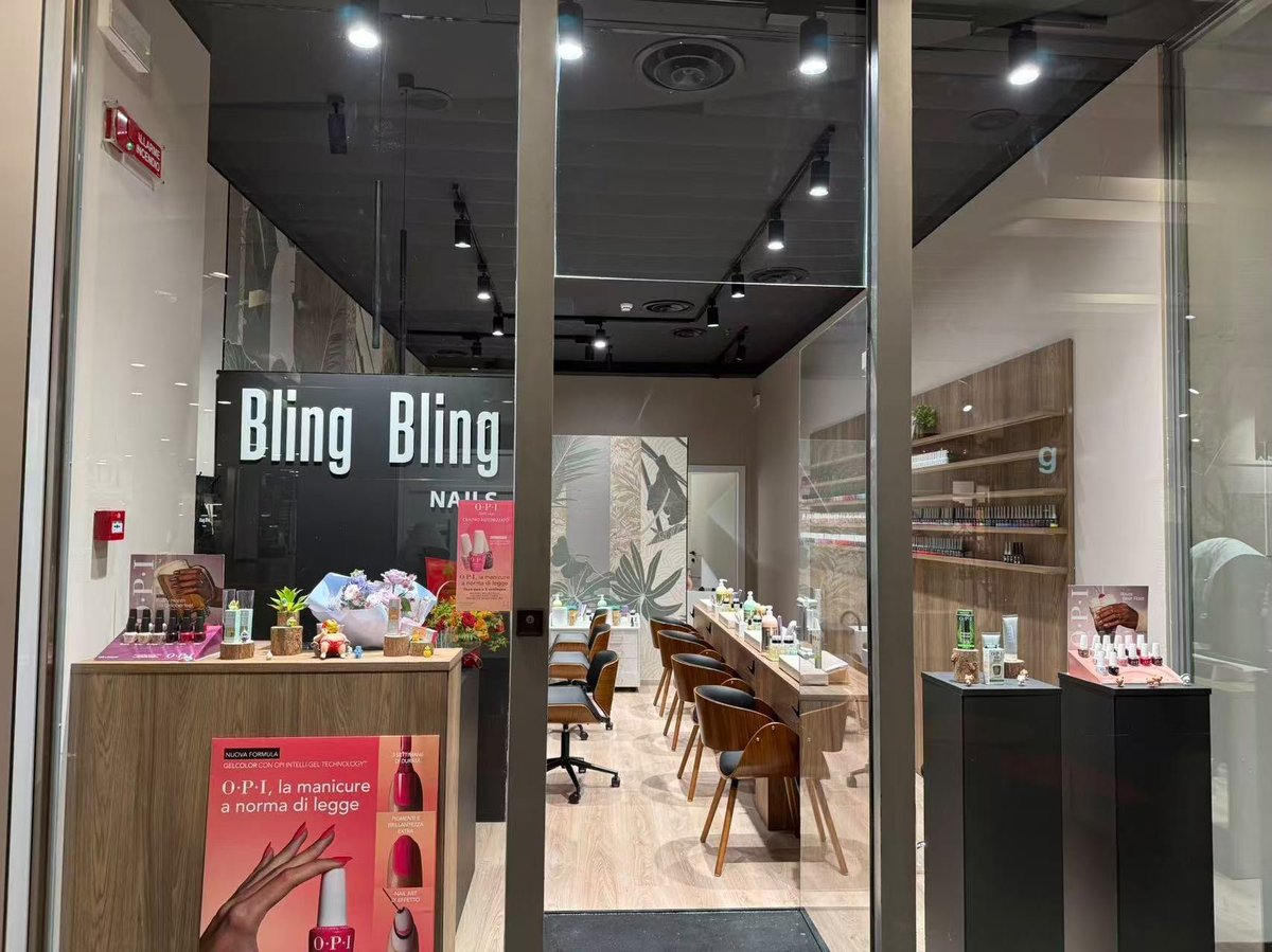 Modern beauty salon storefront with Bling Bling signage, wooden counter with products, and interior seating area visible through glass doors
